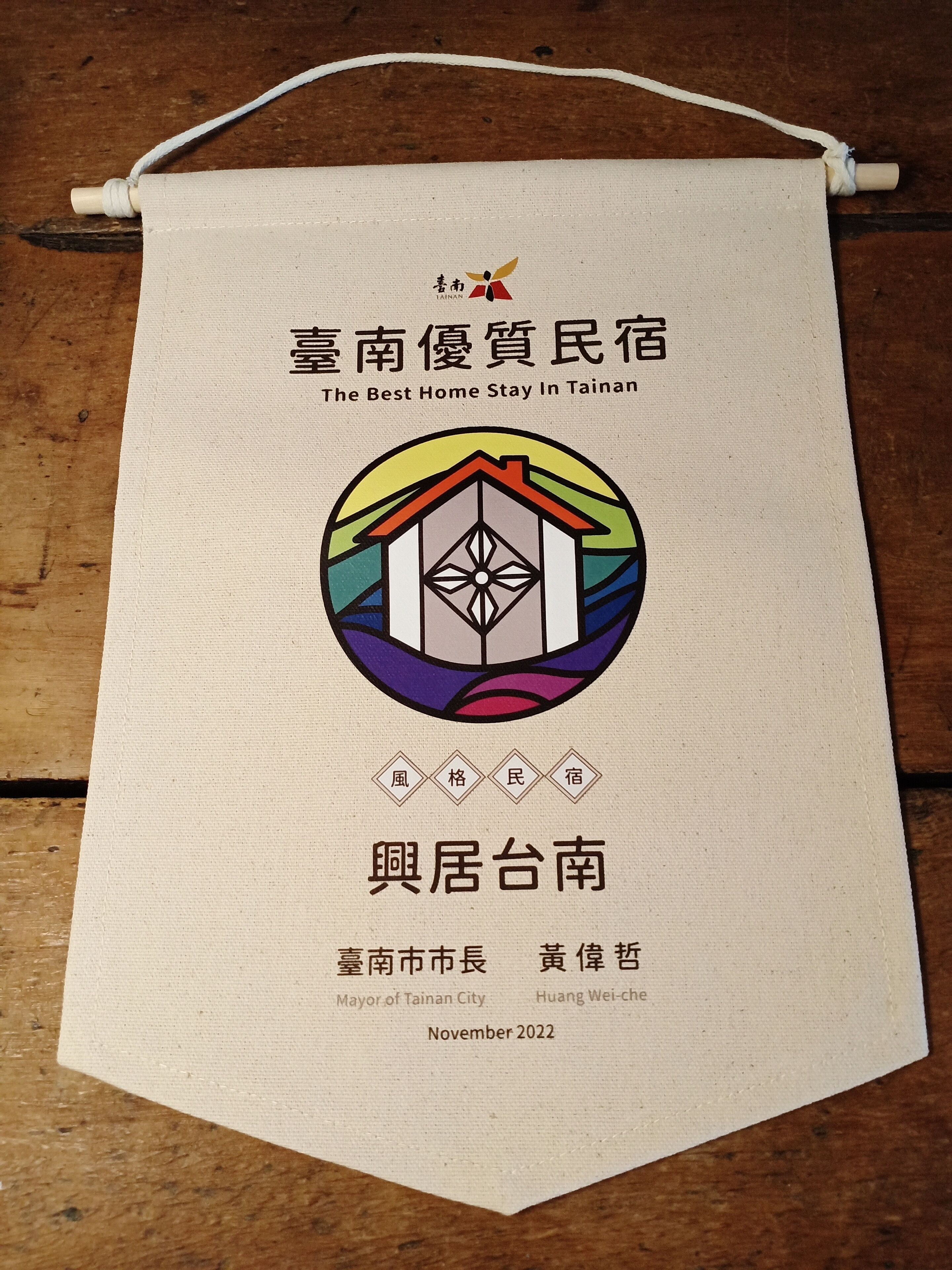 Une bannière publicitaire pour une offre d’hébergement dans un hôtel de Tainan, avec un logo coloré et un texte en chinois et en anglais.