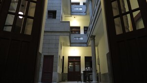 A narrow alleyway with a building featuring a central door and a small table with chairs. - The Vintage Maison Tainan (Tainan)