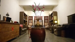 A traditional living room with a large vase of flowers, a wooden cabinet, and a sofa. - The Vintage Maison Tainan (Tainan)