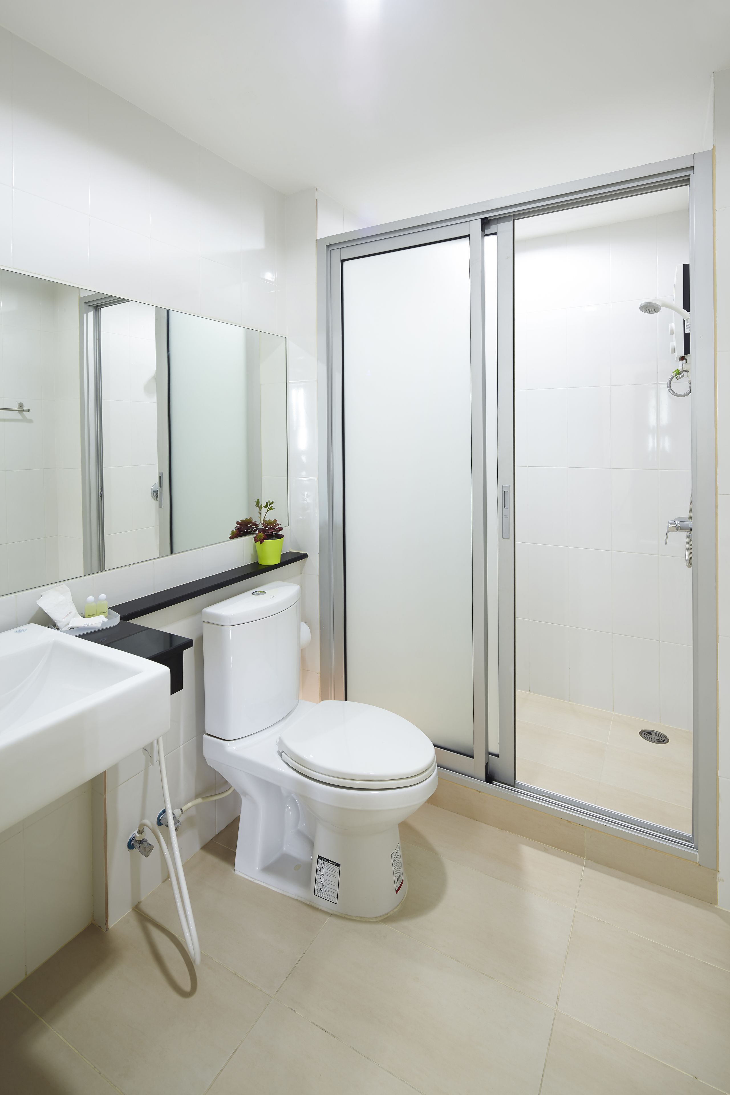 Een moderne badkamer met toilet, wastafel en douche.
