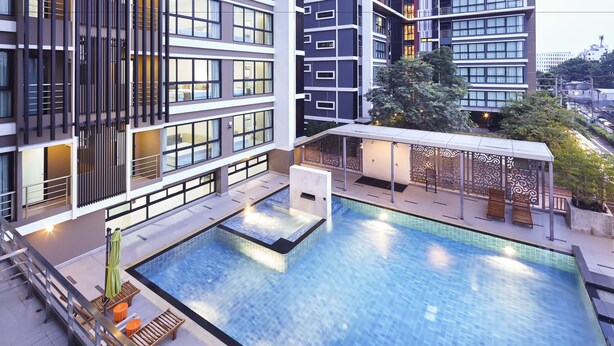 Een modern hotel met een dakterraszwembad, terras en uitzicht op de stad.