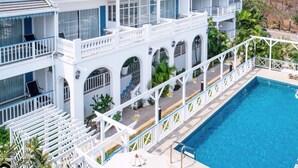 A multi-story hotel with a swimming pool, balconies, and arched windows. - Somewhere Koh Sichang (Ko Sichang)