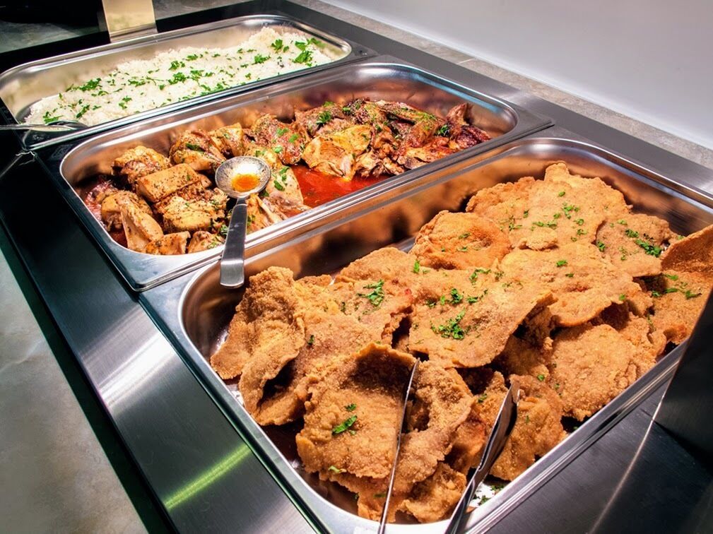 A buffet with various dishes including rice, a meat dish, and breaded items.
