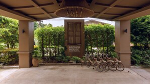 Una entrada techada con un letrero que dice "BROWN HOUSE" y una fila de bicicletas estacionadas afuera.
