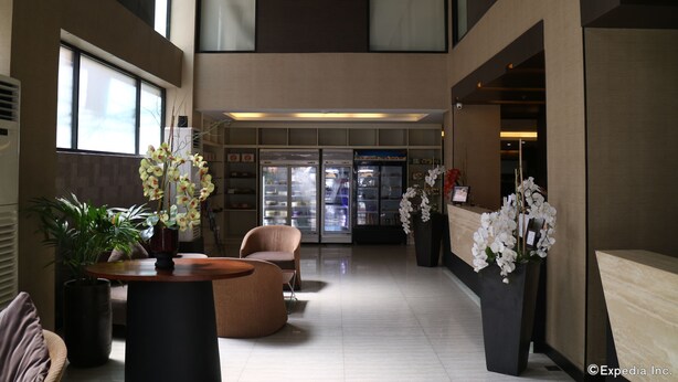 A spacious lobby with a high ceiling, a reception desk, seating area, and a refrigerator. - GT Hotel Iloilo (Iloilo)