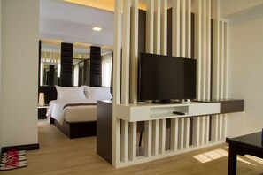 A modern hotel room with a large bed, a TV mounted on a white panel, and a wooden floor. - Hotel Accord (Yangon)