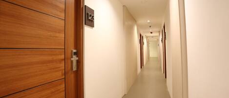 A hallway with wooden doors and a sign indicating room number 123.
