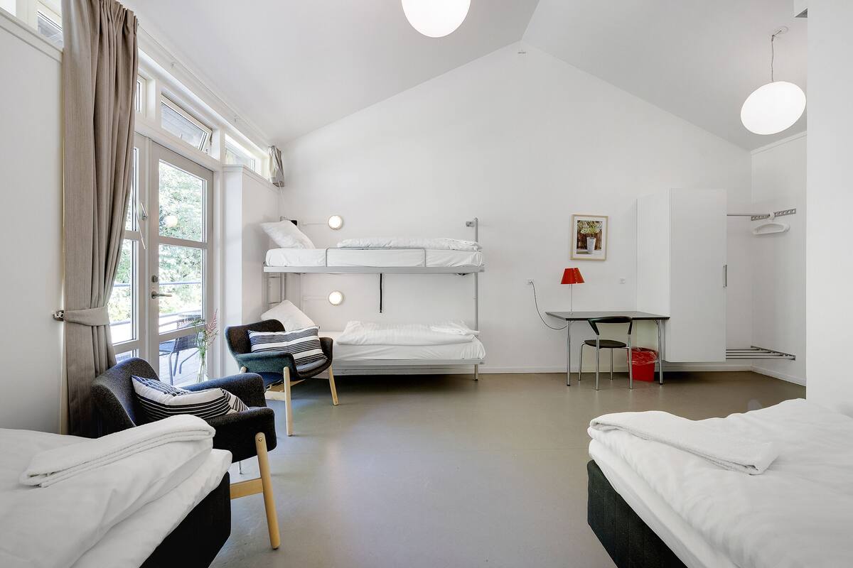 Una habitación moderna y bien iluminada con literas, un escritorio y una silla.