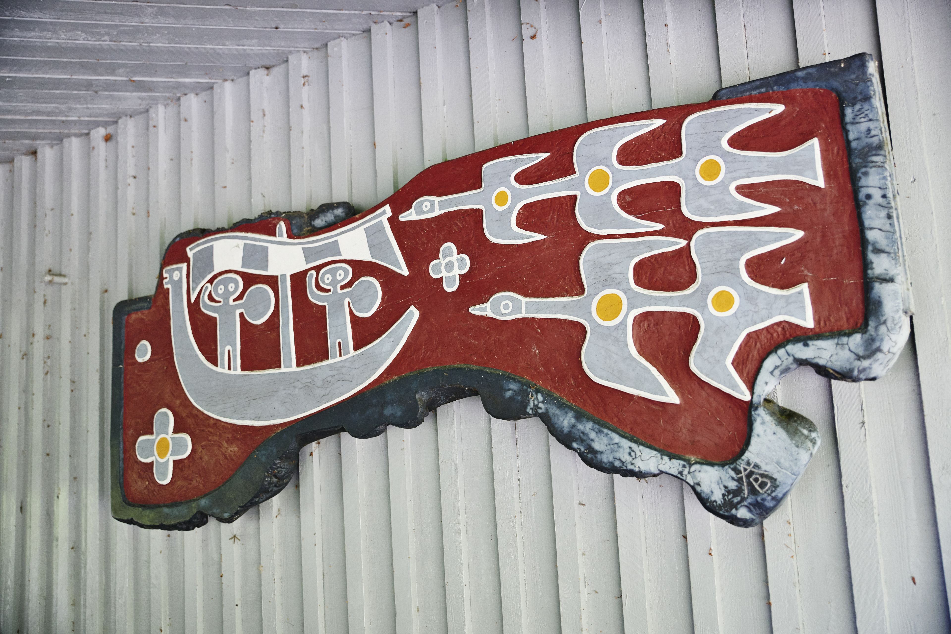 A decorative wall piece with abstract shapes and symbols.