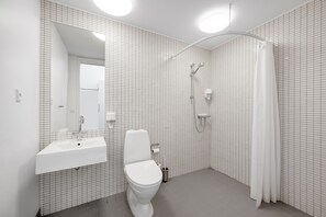A modern bathroom with a white sink, toilet, and shower. - Danhostel Hillerød (Hillerod)