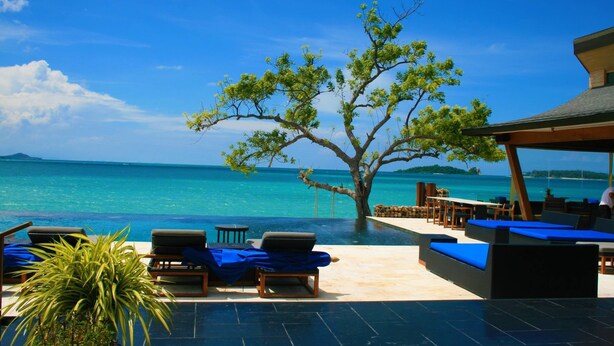 A resort with a pool area, lounge chairs, and a view of the ocean. - Tides Boutique Samui Resort & Spa (Koh Samui)