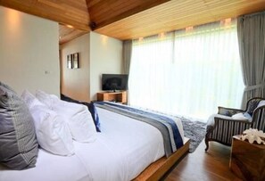 A bedroom with a large bed, a television, and a chair. - Tides Boutique Samui Resort & Spa (Koh Samui)