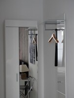 Un baño moderno con cabina de ducha de vidrio, un lavabo blanco y un perchero para toallas.