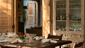 Une table de salle à manger en bois, mise avec de la verrerie, des assiettes et des serviettes.