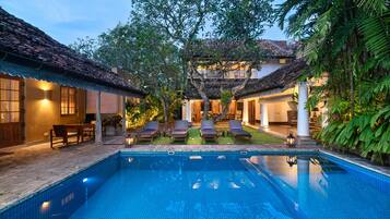 Alberca al aire libre, sombrillas en la alberca y camastros