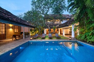 Una piscina al aire libre, sombrillas, tumbonas
