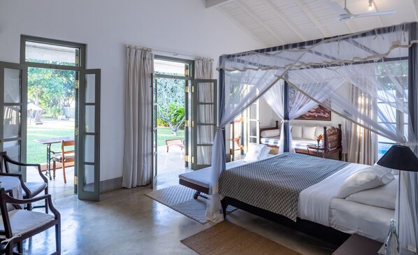 Un dormitorio con cama, mesita de noche y vista al jardín.