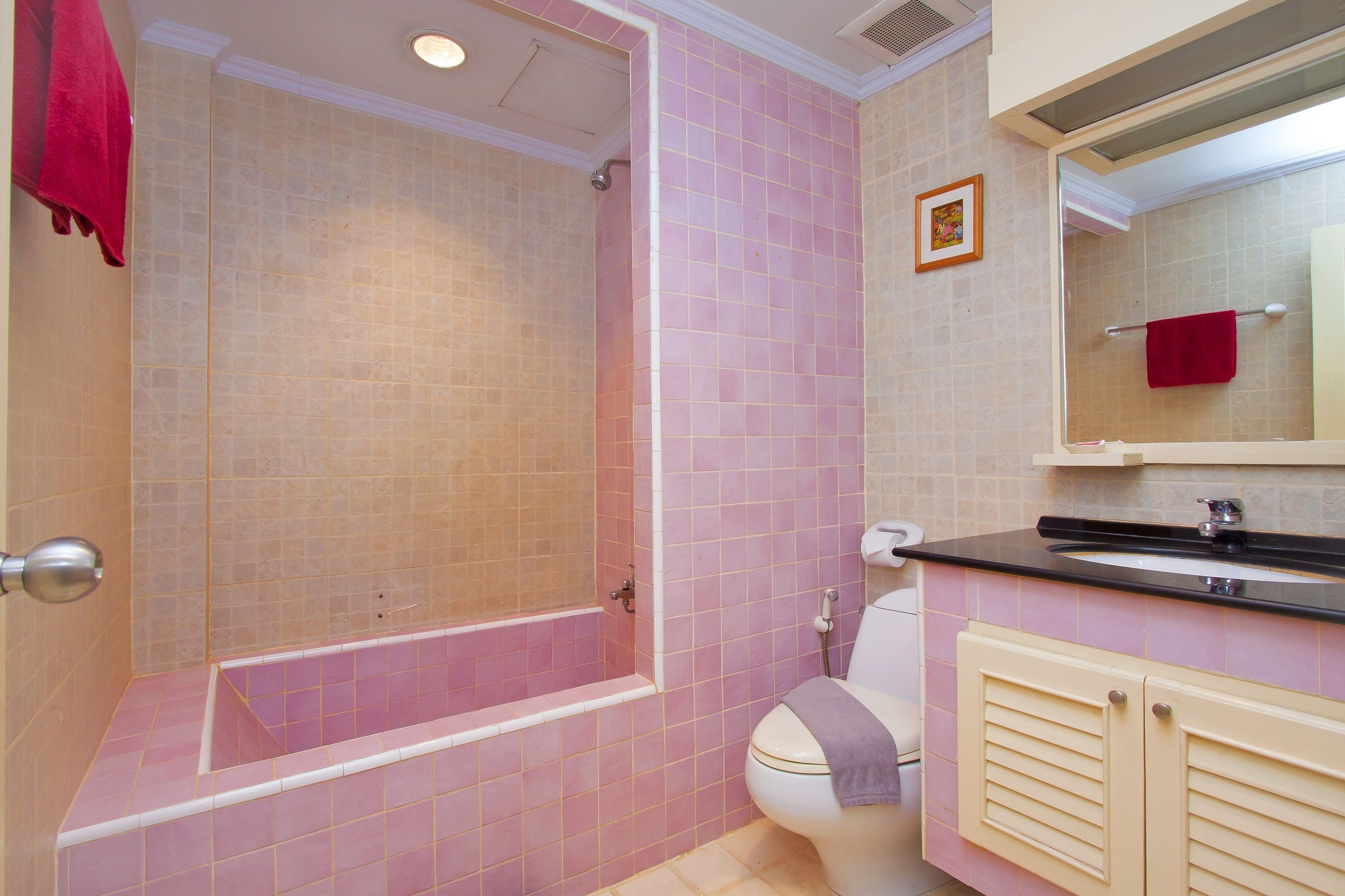 A bathroom with a shower, toilet, sink, and vanity.