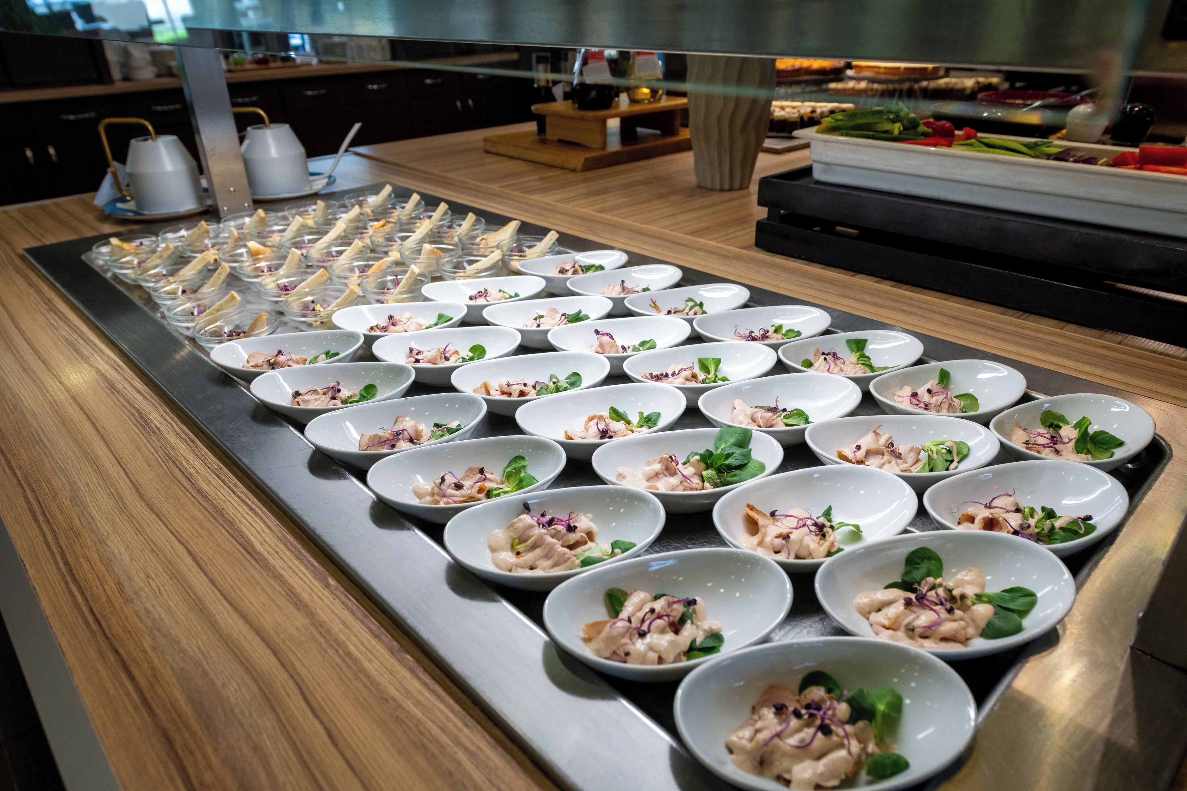 A buffet table with neatly arranged food bowls.