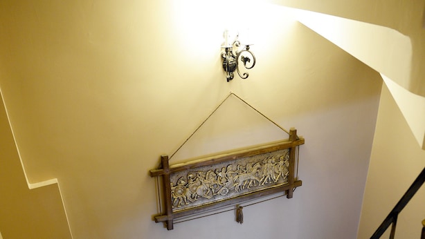 Una escalera con escalones de mármol y un adorno en la pared.