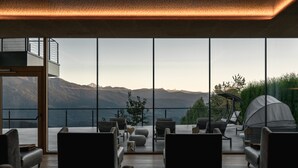 Un'elegante sala relax con vista sulle montagne e un lago.