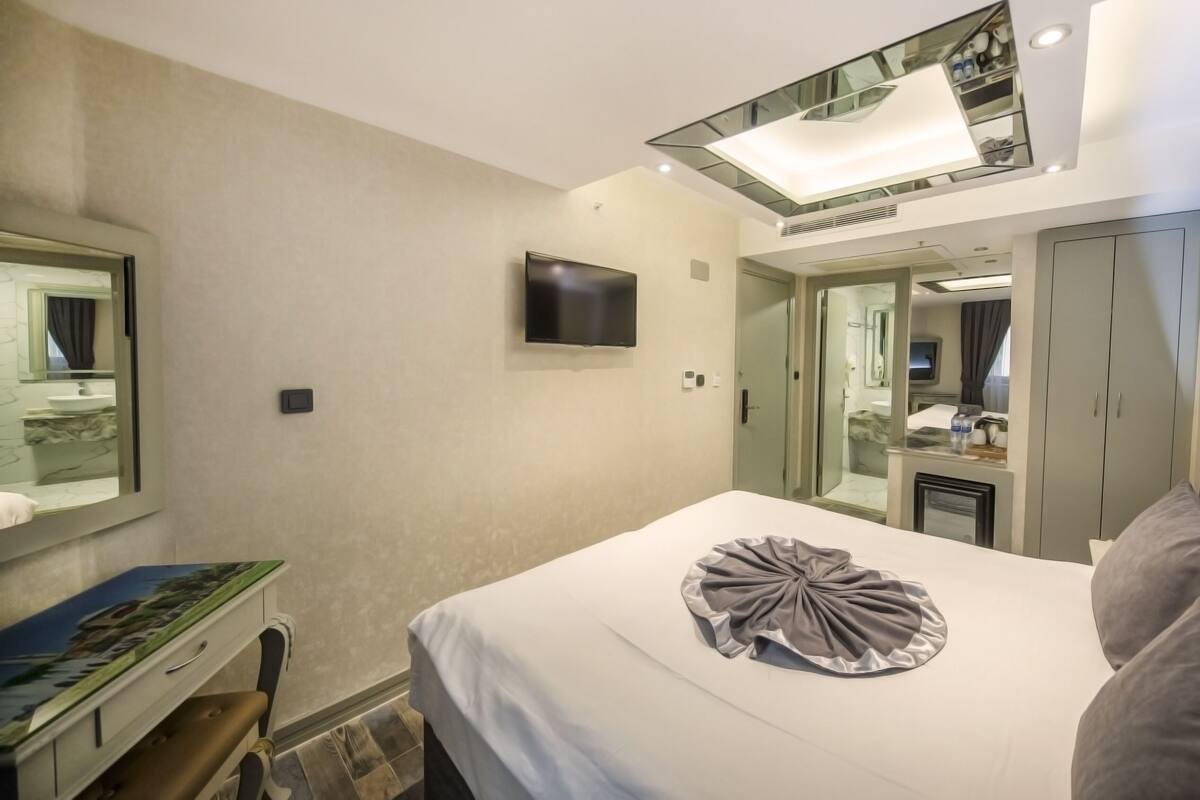 Sengetøy av topp kvalitet, dundyner, minibar og safe på rommet