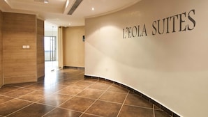 A hotel interior with a curved wall displaying 'L'EOLA SUITES' and a tiled floor. - L'eola Suites (Abuja)