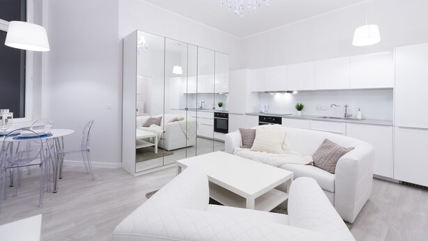 A modern, white-themed living room with a dining area, a sofa, and a coffee table. - Homewell Apartments Stara Piekarnia (Poznan)