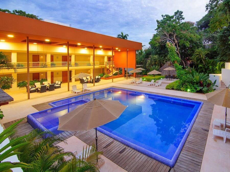 Una piscina al aire libre, sombrillas, sillones reclinables de piscina