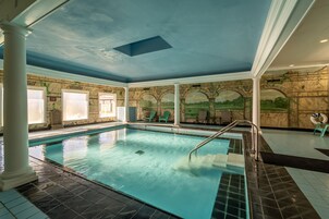 Una piscina cubierta, una piscina al aire libre, tumbonas