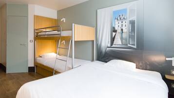 Habitación de hotel con literas, una cama individual, un armario y un amplio ventanal con vista a un edificio.