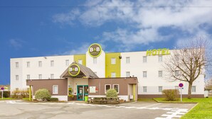 A B&B hotel with a flat facade, a green entrance, and a clear sky. - B&B HOTEL Tours Nord 2 La petit Arche (Tours)