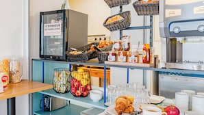 A breakfast buffet with bread, pastries, and fruit. - B&B HOTEL Chatellerault (Chatellerault)