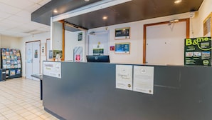 A reception desk with a sign for 'Chambres' indicating rooms, a B&B sign, and a 'Respirez! Breathe!' poster. - B&B HOTEL Chatellerault (Chatellerault)