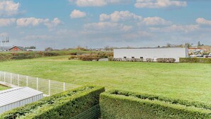 A grassy field with a white building, a fenced area, and a clear sky. - B&B HOTEL Chatellerault (Chatellerault)