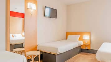 Habitació d'hotel amb un llit individual, una taula petita, una cadira, un televisor fixat a la paret i un mirall.