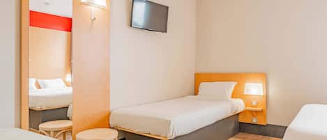 Habitación de hotel con una cama individual, una mesita, una silla, un televisor fijado a la pared y un espejo.