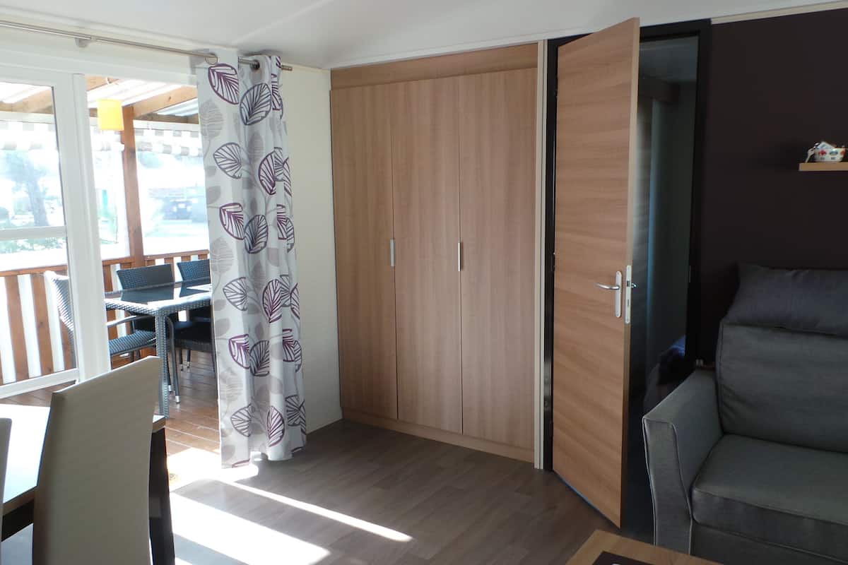 Une pièce dotée d’une porte coulissante, d’un canapé et d’un coin repas avec des chaises et une table.