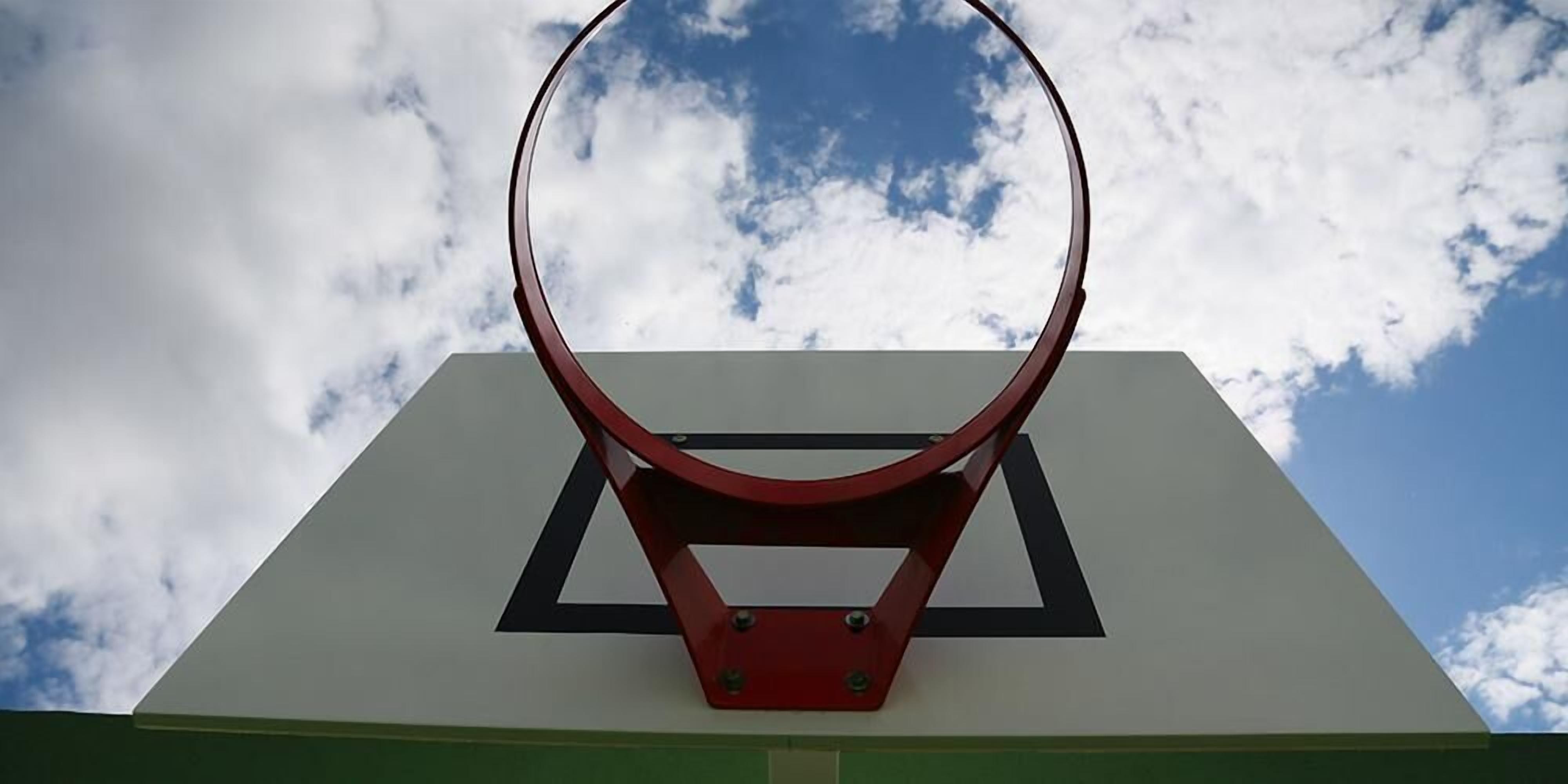 A basketball hoop with a clear sky in the background.