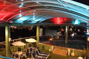 Una piscina al aire libre, sillones reclinables de piscina