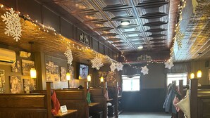 A restaurant with wooden booths, string lights, and snowflake decorations. - The Inn at Montrose (Montrose)
