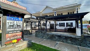 A hotel with a sign for rooms and suites, a gym, and a covered outdoor seating area. - The Inn at Montrose (Montrose)
