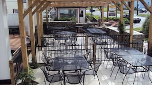 An outdoor patio with multiple tables and chairs, a wooden pergola, and a view of the street. - The Inn at Montrose (Montrose)