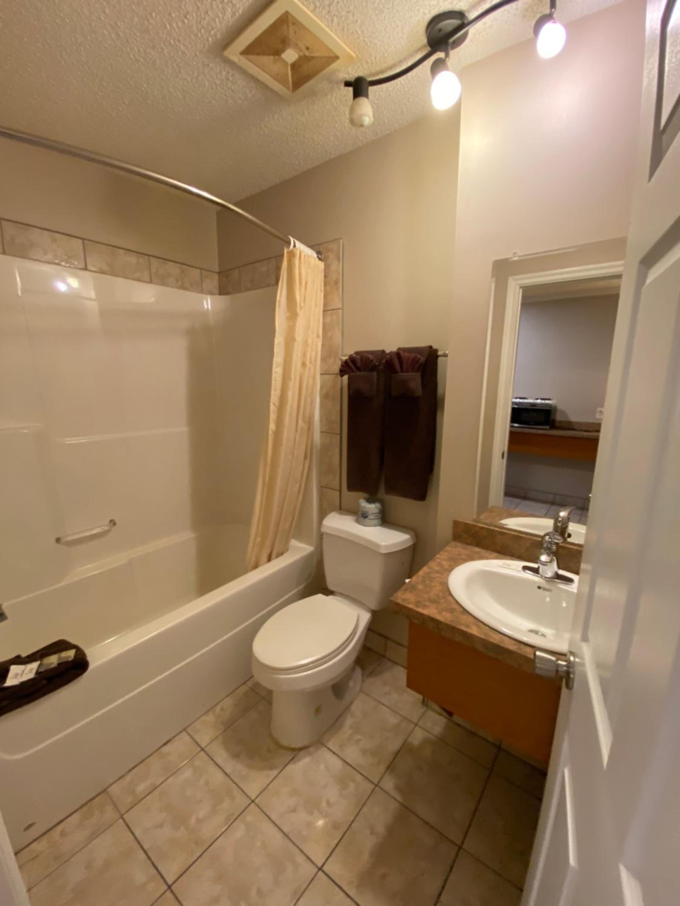 A bathroom with a bathtub, toilet, and sink.