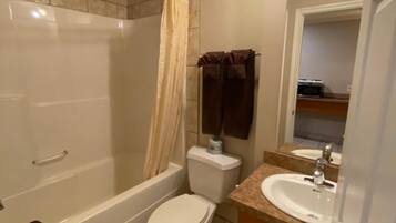 A bathroom with a bathtub, toilet, and sink.