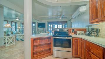 A kitchen with a built-in oven, a stovetop, and wooden cabinets.