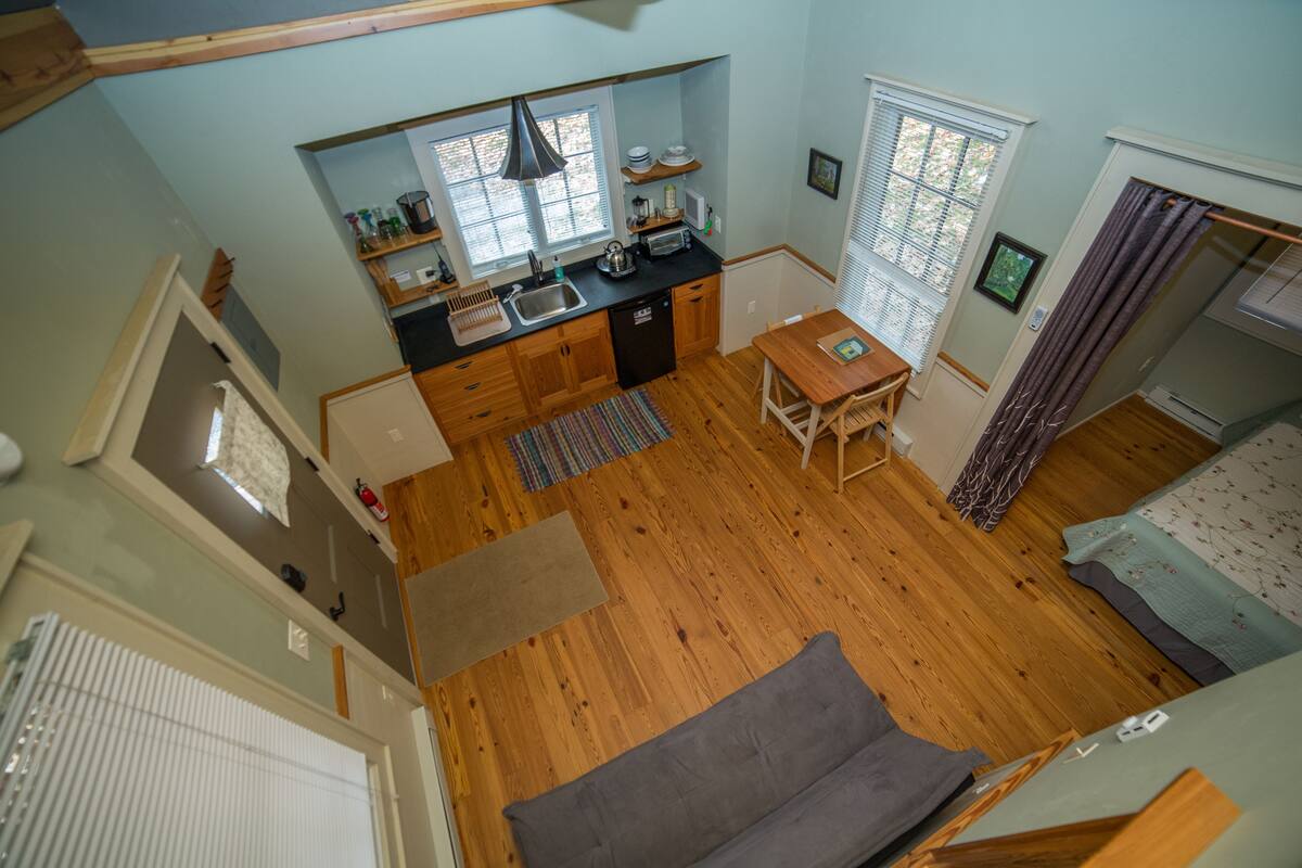 A compact kitchen with wooden cabinets, a sink, and a window.
