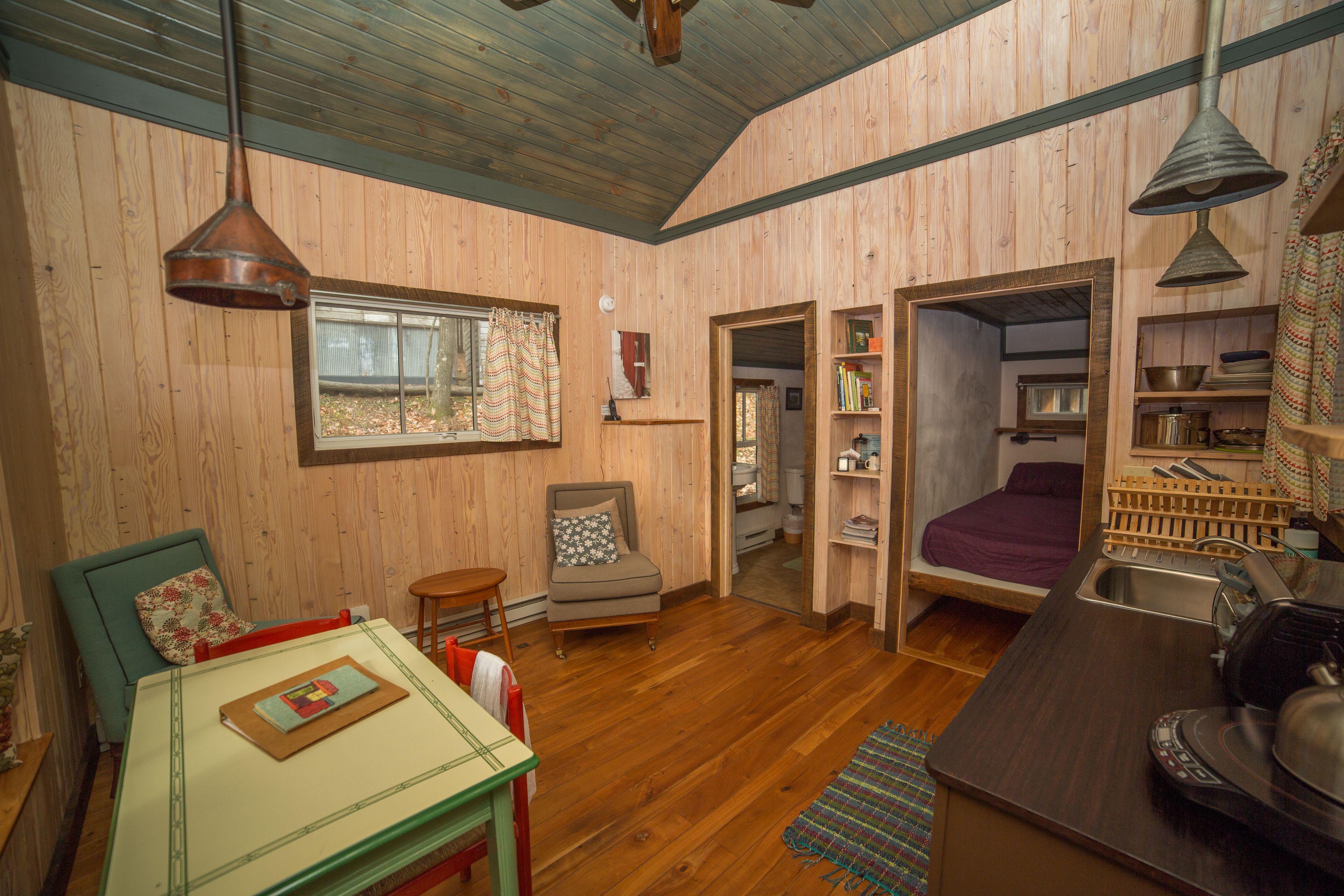 A cozy cabin interior with a dining area, a seating area, and a kitchen.