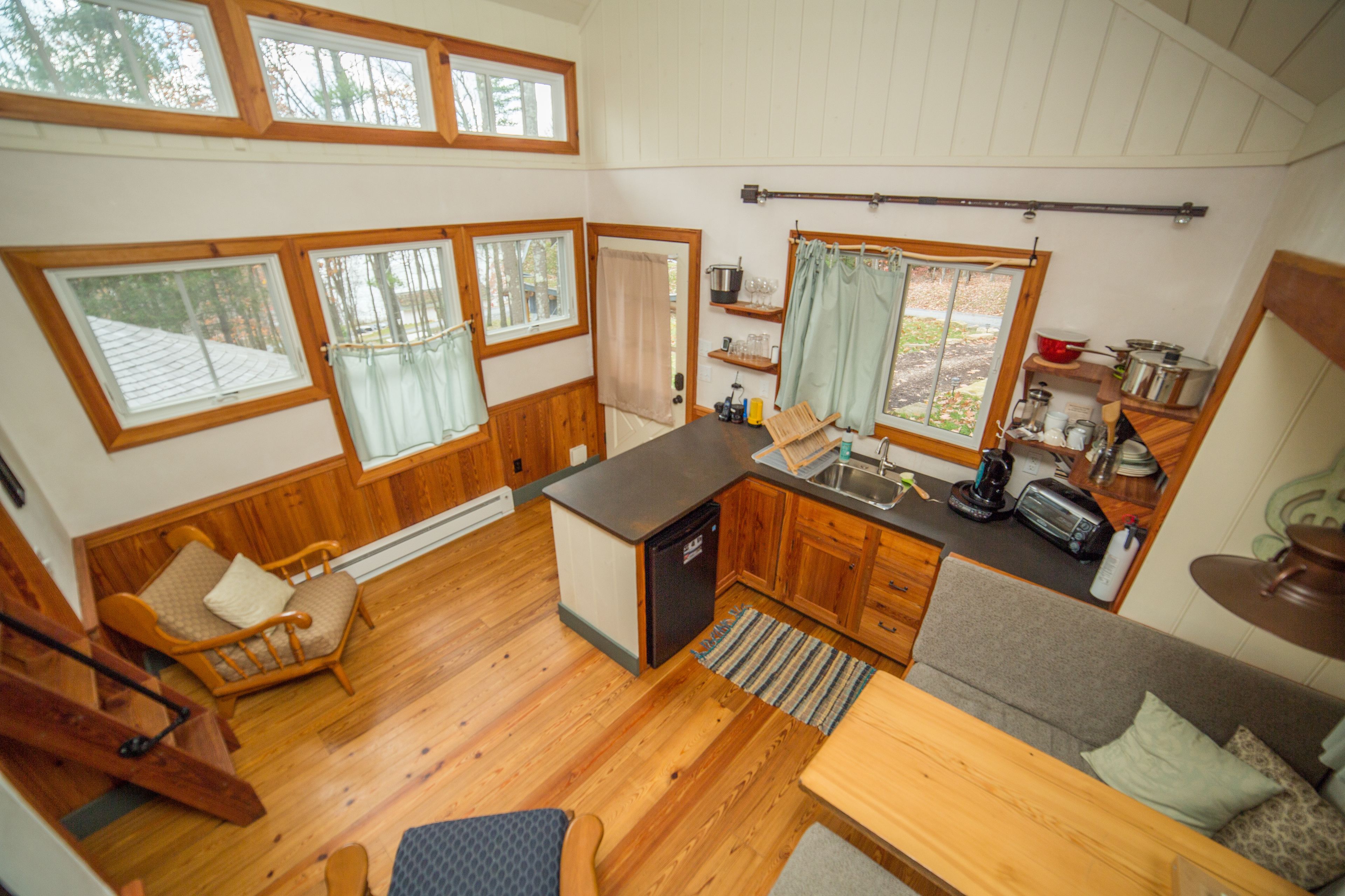 A compact kitchen with wooden cabinets, a built-in sink, and a small dining area with a table and chairs.
