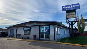 Un motel Howard Johnson by Wyndham con un letrero que indica suites con kitchenette abierta las 24 horas, internet y estacionamiento para camiones grandes.